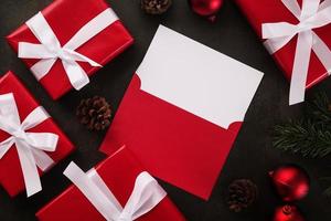 Carte de voeux blanche vierge et maquette d'enveloppe avec des décorations de cadeaux de Noël sur fond grunge photo