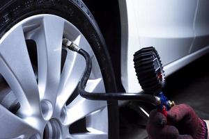 mécanicien automobile vérifie la pression des pneus dans un concept de service d'entretien de voiture de magasin de pneus