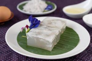 Gelée de noix de coco sur une feuille de bananier avec des fleurs de pois papillon et des orchidées photo