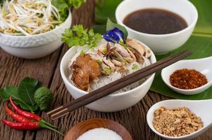 Nouilles au poulet dans un bol avec accompagnements thaïlandais