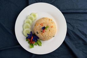 Riz frit aux œufs sur une assiette blanche avec tissu froissé photo