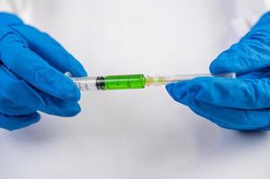 scientifique portant des gants tenant une seringue avec un vaccin pour prévenir la covid-19
