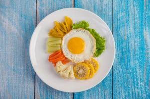 œuf frit américain avec salade, citrouille, concombre, carotte, maïs et chou-fleur photo