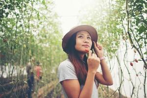 Jeune femme dans une serre avec récolte de tomates biologiques photo