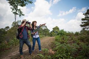 Deux jeunes voyageurs avec des sacs à dos dans la jungle verte photo