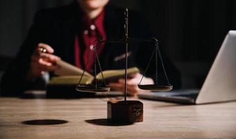 concept de justice et de droit. juge masculin dans une salle d'audience avec le marteau, travaillant avec, clavier d'ordinateur et d'accueil, lunettes, sur table à la lumière du matin photo