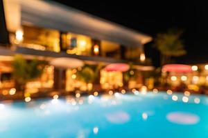 floue bokeh night lights reflet dans la piscine d'été fête de noël eau bleue vacances abstraites et concept d'arrière-plan de vacances. complexe de luxe ou hôtel brouillé les lumières photo