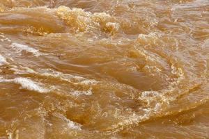 eau de rivière boueuse. eau boueuse sale avec bain à remous et gros plan de mousse blanche. photo