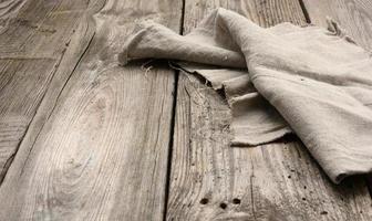 serviette de cuisine en lin gris sur une table faite de vieilles planches de bois, vue de dessus photo