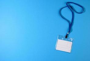 badge en plastique transparent sur un cordon bleu sur fond bleu photo
