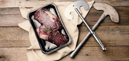 deux couteaux vintage en métal et un morceau de steak de bœuf classique sous vide photo