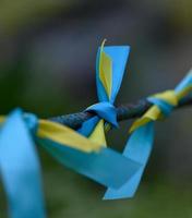 ruban de soie bleu et jaune noué sur un tube métallique. symbole du drapeau ukrainien, lutte pour l'indépendance photo