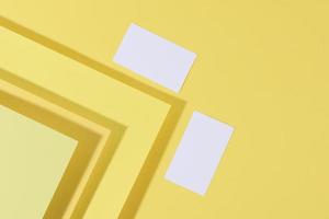 carte de visite rectangulaire blanche vierge sur fond jaune créatif à partir de feuilles de papier avec ombre photo