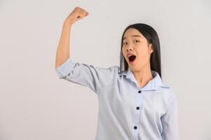 portrait de jeune femme asiatique montrant le geste du gagnant sur fond blanc isolé photo