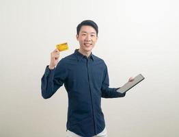 Portrait jeune homme asiatique tenant une carte de crédit et une tablette photo