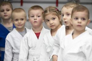 biélorussie, ville de gomil, 15 décembre 2021. école de judo pour enfants. un groupe de petits enfants en kimanos alignés avant l'entraînement. photo