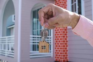 le propriétaire déverrouille la clé de la maison pour une nouvelle maison photo