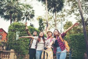 groupe d'amis heureux levant les mains sur fond de ville photo