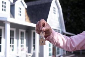 le propriétaire déverrouille la clé de la maison pour une nouvelle maison photo