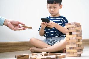 les enfants asiatiques à l'ère des réseaux sociaux qui se concentrent sur les téléphones ou les tablettes. ne se soucient pas du milieu environnant et ont des problèmes oculaires. photo