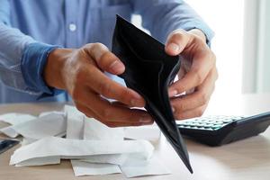 les mains de l'homme ouvrent le sac vide. la pauvreté, la dette et la faillite dans le paiement des factures et des cartes de crédit. concept cassé photo