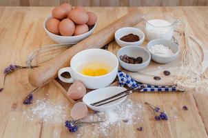 vue de dessus préparation de cuisson sur table en bois, ingrédients de cuisson. bol, oeufs et farine, rouleau à pâtisserie et coquilles d'oeufs sur planche de bois, concept de cuisson photo