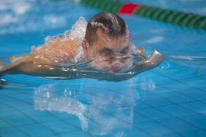 un homme nage dans la piscine en gros plan. photo