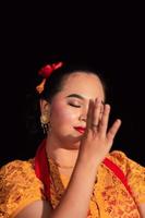 beau visage d'une femme asiatique aux lèvres rouges et maquillage en costume de danse traditionnelle indonésienne après le spectacle de danse photo