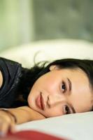 les femmes indonésiennes dorment seules dans son mauvais et elle a les cheveux noirs photo