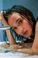 pose féminine chaude au-dessus de l'eau avec les cheveux mouillés et le corps mouillé photo