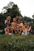 les javanais avec des costumes de danse traditionnels allongés sur l'herbe ensemble pendant la séance photo