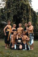 un groupe de balinais pose avec un visage heureux tout en portant des costumes dorés après le spectacle photo