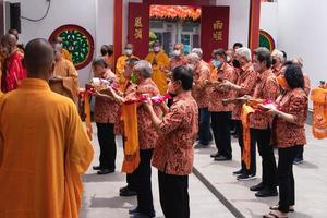 ville de bandung, indonésie, 2022 - le touriste apporte les offrandes aux moines tout en priant le dieu ensemble au temple de bouddha photo