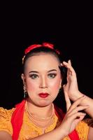 femme indonésienne maquillée aux lèvres rouges portant un collier doré et des boucles d'oreilles dorées photo