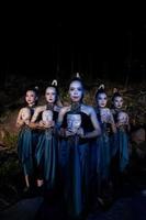 un groupe de femmes balinaises s'alignent avec le masque en bois dans leurs mains tout en portant des costumes de danse traditionnels photo