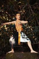 un danseur traditionnel avec des vêtements dorés et une couronne dorée posant courageusement dans la jungle photo