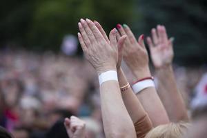 une main dans un poing pour protester contre une foule floue de personnes. photo