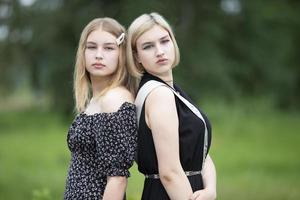 deux soeurs. de belles jeunes filles se tiennent dos à dos. photo