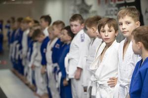 biélorussie, ville de gomil, 15 décembre 2021. école de judo pour enfants. un groupe de petits enfants en kimanos alignés avant l'entraînement. photo