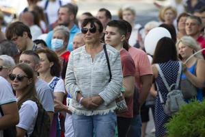 biélorussie, gomil, 16 juillet 2020. rue de la ville bondée. une femme âgée se tient dans une foule de personnes. photo