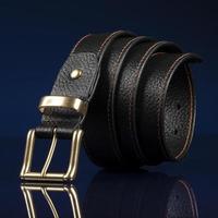 ceinture en cuir noir sur fond bleu foncé. photo