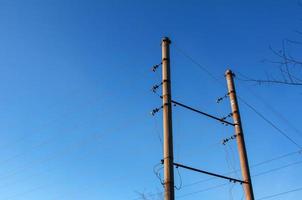 poteau électrique avec un fil linéaire contre le gros plan de ciel bleu. poteau électrique de puissance. photo