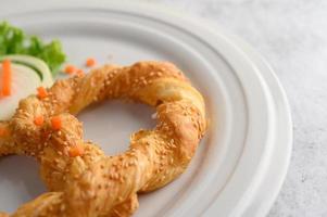 bretzel sur un plat blanc avec laitue et carottes photo