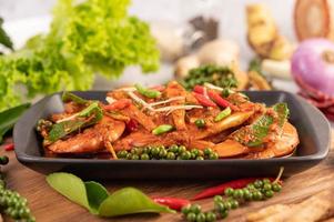 Crevettes chu-chi sur une assiette avec des graines de poivre frais