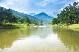 rivière, forêt et montagnes avec un ciel bleu nuageux photo