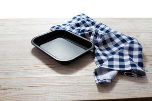 plateau vide pour la cuisson des aliments et nappe sur maquette de fond en bois photo