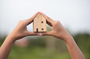 nouveau concept de maison - jeune famille avec maquette de maison de rêve dans les mains photo