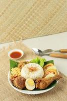 nasi uduk ou nasi lemak, riz cuit à la vapeur avec divers accompagnements. photo