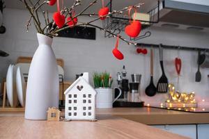 clé de la maison de la maison confortable avec un décor de saint valentin sur la table de la cuisine. cadeau pour la saint valentin, nid d'amour familial. construction, conception, projet, déménagement dans une nouvelle maison, hypothèque, location et achat immobilier photo