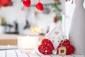 clé de la maison de la maison confortable avec un décor de la Saint-Valentin sur la table de la cuisine. cadeau pour la saint valentin, nid d'amour familial. construction, conception, projet, déménagement dans une nouvelle maison, hypothèque, location et achat immobilier photo